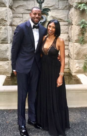 Andre and his wife posing in matching black dresses 
